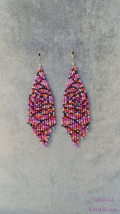 two pairs of beaded earrings on a gray surface