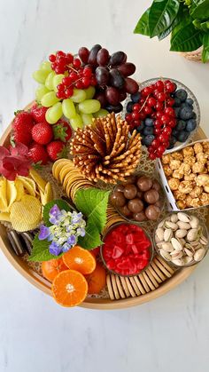 a platter filled with fruit, nuts and other foods on top of a table