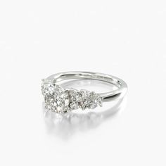 a three stone diamond ring on a white background