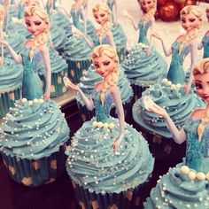 cupcakes decorated with blue frosting and frozen princesses are displayed in front of other cupcakes