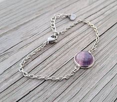 These bracelet is perfect for anyone! It has a round cabochon of purple and green fluorite. The bracelet is a silver color. The bezel is silver plated and the chain is stainless steel.  All jewelry items come in a gift box. This bracelet is really unique. The bracelet is adjustable and has a maximum measurement of about 8.5 inches and a minimum of 6.5 inches.  **If you need a different length bracelet, please leave me a note at checkout.  *SEE my store for cufflinks, tie clips, & earrings. This would be great for any time of the year! Perfect for a wedding, for a Christmas gift, anniversary gift, for Mother's Day, or a birthday. This listing is for one bracelet  Please let me know if you have any questions. #br8 Nickel Free Purple Bracelets, Gift For Mom Birthday, Fluorite Stone, Birthday Gift For Women, Green Fluorite, Tie Clips, Mom Birthday, Mom Birthday Gift, Purple Green