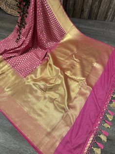 Glamorous Banarsi saree in rogue pink with gold zari butas all throughout and tassels on the palla Fall attached. Matching blouse fabric included. Note: The color of the products may slightly vary according to the ambient lighting conditions and the color calibration of LED devices. If you would like more clarity before your purchase, please drop us a message . Bollywood Style Gold Pre-draped Saree With Pallu, Gold Anarkali Banarasi Silk Pre-draped Saree, Festive Gold Pre-draped Saree With Zari Weaving, Pink Bollywood Pre-draped Saree With Meenakari, Gold Katan Silk Pre-draped Saree For Eid, Festive Celebration Pre-draped Saree With Zari Weaving, Navratri Banarasi Silk Blouse With Latkans, Traditional Gold Pre-draped Saree For Navratri, Gold Bollywood Pre-draped Saree For Celebration