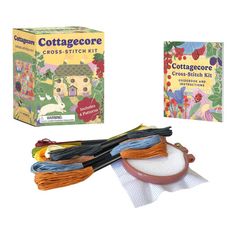 the cottage cross stitch kit is in its box and it's contents are laid out