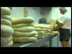 a man standing in front of stacks of bread