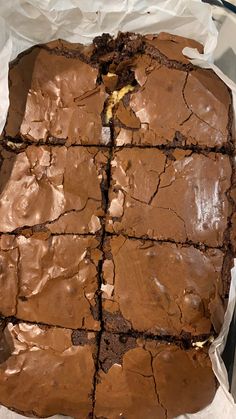 chocolate brownies are cut into squares and placed on wax paper