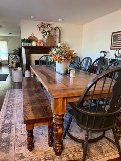 a dining room table and chairs in front of a fire place with a potted plant on top