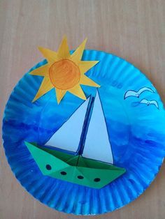 a paper plate that has a boat on it and the sun in the sky above