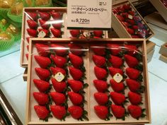 there are many strawberries in the box on display at the store and one is for sale