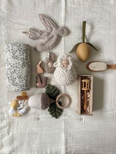 an assortment of stuffed animals and toys laid out on a white cloth covered tablecloth