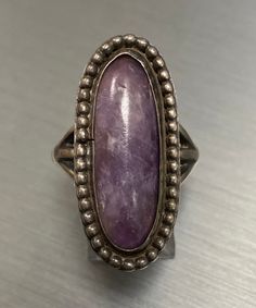 A beautiful vintage piece available for sale!  This unique vintage ring is set with a genuine opaque cabochon amethyst. This ring is a finger size 6 3/4 and weighs 8.6 grams. This ring will be shipped promptly in a gift pouch. We purchased a large estate of Vintage Silver Jewelry that I will be adding to our shop in the coming weeks, please keep coming back to view the new additions. Collectible Oval Cabochon Amethyst Ring, Vintage Rings With Large Stone For Collectors, Vintage Rings With Large Stone For Collectible, Vintage Collectible Rings With Large Stone, Vintage Oval Cabochon Moonstone Ring, Vintage Moonstone Oval Cabochon Ring, Vintage Jewelry With Natural Stones For Anniversary, Vintage Natural Stones Jewelry For Anniversary, Vintage Round Natural Gemstones