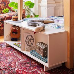 a bed room with a neatly made bed and a book shelf filled with books on top of it