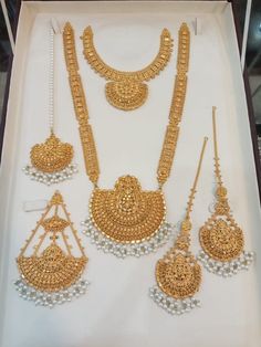 an assortment of gold jewelry on display in a box