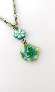 This sweet necklace is made using a vintage enamel frog on lily pad sterling silver pendant, a glass flower bead, and a crystal beaded necklace.  The necklace is 16 inches long, with a 1 1/2 inch drop.It is handmade and a one of a kind! Whimsical Blue Jewelry With Flower Charm, Whimsical Czech Glass Silver Jewelry, Whimsical Silver Czech Glass Jewelry, Whimsical Green Pendant Jewelry, Nickel-free Green Flower Pendant Jewelry, Unique Green Flower Pendant Jewelry, Handmade Whimsical Flower Pendant Jewelry, Whimsical Green Nickel-free Jewelry, Whimsical Handmade Flower Pendant Jewelry