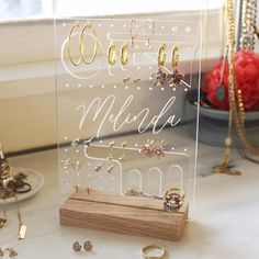 a clear acrylic sign with earrings on it