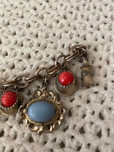 Red and blue charm bracelet. Doesn't have a closure! Can be used as decor or can repair the closure Retro Metal Bracelets With Vintage Charm, Retro Metal Bracelet With Vintage Charm, Vintage Metal Bracelet With Charm, Blue Metal Charm Bracelet With Lobster Clasp, Collectible Vintage Charm Costume Bracelets, Vintage Charm Costume Jewelry Bracelet, Vintage Charm Bracelet With Lobster Clasp, Vintage Dangle Charms Bracelets, Vintage Metal Charm Bracelet