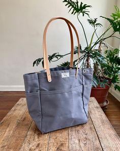 This versatile, fun tote is our best selling go-to for daily carry. Small batch handmade in our Omaha, NE studio using sturdy water repellent duck canvas and American full grain leather. WE ARE HANDMAKING MORE TOTES BUT THEY WILL NOT BE AVAILABLE UNTIL 12/20/2024. PLEASE USE OUR "NOTIFY ME" FEATURE (BELOW), AS WE'LL BE UPDATING THE SITE PERIODICALLY. ALSO, CONSIDER A GIFT CARD! Everyday Duck Canvas Bag With Pockets, Everyday Coated Canvas Bag With Reinforced Handles, Casual Duck Canvas Bag For Everyday Use, Duck Canvas Bag With Reinforced Handles For Daily Use, Coated Canvas Bag With Reinforced Handles For Everyday Use, Waxed Canvas Bag With Leather Handles For On-the-go, Everyday Canvas Bag With Duck Canvas Lining, Duck Canvas Tote Bag With Canvas Lining, Daily Use Shoulder Bag With Duck Canvas