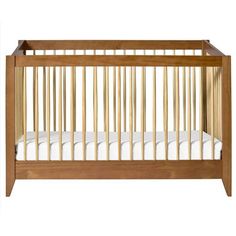 a wooden crib with white sheets on the bottom and sides, against a white background