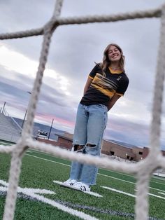 a woman standing in front of a soccer goal