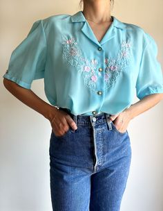 ATTENTION: if you order something, the expected delivery of the package to the post office will only be made on September 16th. Vintage blouse in deep blue with beautiful embroidered flower details. Closes with buttons at the front. Ask for measures if you need. Size: S/M/L Model is 1,71 cm tall and wears size S for reference. I use a spring in the waist. "Please keep in mind that all pieces listed are true vintage, so they can come with some usual signs of vintage wear." You can follow us on in Blue Embroidered Collared Blouse, Vintage Embroidered Short Sleeve Tops, Vintage Blue Short Sleeve Blouse, Retro Short Sleeve Blouse With Floral Embroidery, Retro Embroidered Short Sleeve Blouse, Retro Short Sleeve Embroidered Blouse, Vintage Blue Embroidered Blouse, Blue Embroidered Button-up Blouse, Vintage Light Blue Summer Shirt