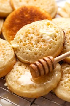 some cookies and honey on a plate with a wooden stick