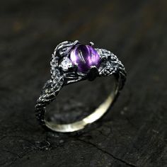 Embrace the allure of ancient legends with our Amethyst Snake Ring. Meticulously handcrafted to mimic the intricate scales of a mystical serpent, this ring is a treasure for any fantasy jewelry lover. The rich purple amethyst is nestled within the serpent's coils, symbolizing wisdom and royalty. Perfect for those who are drawn to medieval aesthetics or have a penchant for gothic glamour. Make a bold statement with this unique, textured silver ring that whispers tales of enchanted realms and serpentine magic. Care Instructions: To keep your jewelry looking its best, avoid contact with chemicals, cosmetics, and mechanical damage. Store your jewelry in special cases to prevent scratches and maintain its shine. Additional Features: Custom Orders: We also provide a custom order service. If you Spiritual Metal Wedding Rings, Spiritual Stainless Steel Nickel-free Jewelry, Symbolic Nickel-free Oval Jewelry, Symbolic Oval Nickel-free Jewelry, Nickel-free Oval Symbolic Jewelry, Unique Nickel-free Jewelry For Wedding, Unique Nickel-free Wedding Jewelry, Unique Engraved Metal Jewelry, Spiritual Antique Silver Nickel-free Jewelry