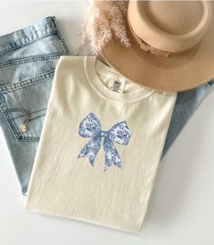 So cute!  EMBROIDERED Toile EMBROIDERED Couquette Bow shirt 🎀 PREMIUM VINTAGE style Comfort Colors Embroidered Tee! * 100% ring-spun cotton * Fabric weight: 6.1 oz/yd² (206.8 g/m²) * Garment-dyed * Relaxed fit * 7/8″ double-needle topstitched collar * Twill-taped neck and shoulders for extra durability * Double-needle armhole, sleeve, and bottom hems * Blank product sourced from Honduras This product is made especially for you as soon as you place an order, which is why it takes us a bit longer Blue Toile, Bow Shirt, Bow Shirts, Embroidered Tee, Honduras, Gift For Mom, Vintage Stil, Comfort Colors, Style Vintage