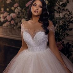 a woman in a wedding dress posing for the camera