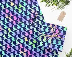 the wrapping paper is blue with multicolored triangles and has a brown tag on it