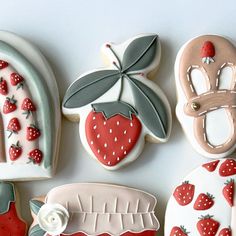 decorated cookies are arranged in the shape of strawberrys and horseshoes with leaves on them