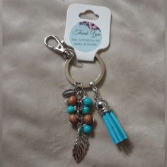 a keychain with beads and charms attached to it's side on a bed