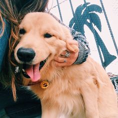 a woman holding a dog with its mouth open