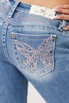 Low-rise, light-wash slim bootcut jeans- Butterfly design in pink and silver embroidery with matching yoke design- Mini silver rhinestone rivets throughout design- White leather logo brand patch- Rhinestone rivets- 5-pocket design- Slight fading Model is wearing size: 26Model Measurements:Height: 5'8"Bust: 35"Waist: 26"Hips: 39" Fabric Content: 52% Cotton, 27% Lyocell, 20% Polyester, 1% Elastane Care: Gentle machine wash inside-out with like colors in cold water. Tumble dry low. Style No. L9330S