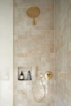 a shower head and hand held shower faucet in a tiled bathroom