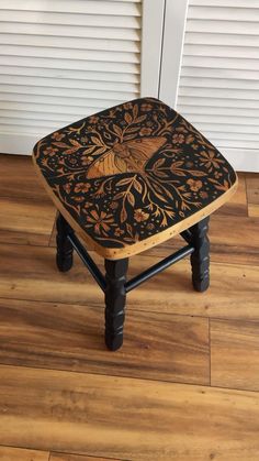 a small wooden stool sitting on top of a hard wood floor