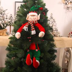 a christmas tree with an elf doll hanging from it