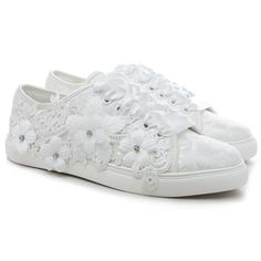 a pair of white shoes with flowers on the side and lace around the soles