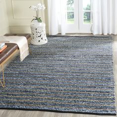 a blue rug in a living room next to a window