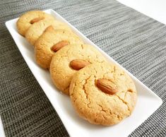 four almond cookies on a white plate