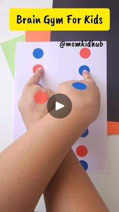 a child's hand is holding a piece of paper with dots on it and the words brain gym for kids