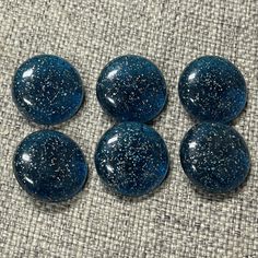 four blue marbles sitting on top of a cloth