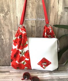 a red and white flowered purse with sunglasses