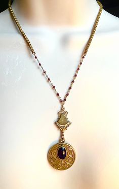 I made this out of a lovely old Art Nouveau locket that does not open. It has a garnet on it and there is an Edwardian element as well. It has a gold and ruby rosary chain. Elegant Handmade Antique Gold Locket Necklace, Antique Garnet Pendant Necklace, Victorian Ruby Necklace For Formal Occasions, Antique Ruby Necklace For Formal Occasions, Victorian Locket Pendant Necklace With Vintage Charm, Red Victorian Engraved Necklace, Victorian Red Engraved Necklace, Ornate Oval Pendant Necklace With Vintage Charm, Antique Gold Necklaces With Vintage Charm