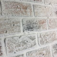 an old brick wall is covered in snow