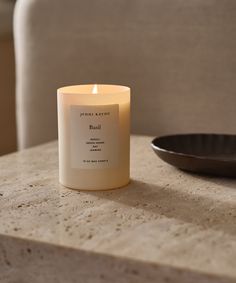 a candle sitting on top of a table next to a bowl