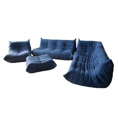 three blue couches and one chair are sitting on the floor in front of a white background