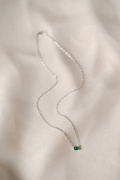 The Ezra Pavé Chain Necklace showcases one gleaming stone on a graceful chain, a brilliant accent for your daily necklace stack. Part of our Stackable Jewelry assortment. Chain necklace with one claw-set emerald cut simulated stone. Gold: 18K gold plated brass. Silver: rhodium plated brass. Nickel- and lead-free. 16" long with 2" extender. Avoid water, soap, and harsh chemicals. Store in a box or bag in a cool, dry place. Clean using a dry soft cloth. Elegant Green Clavicle Chain Necklace, Green Emerald Necklace With Adjustable Chain, Elegant Green May Birthstone Chain Necklace, Classic Silver Necklace With Emerald, Emerald Pendant Necklace With Delicate Chain, Elegant Emerald Necklace With Cable Chain As Gift, Elegant Emerald Necklace With Cable Chain, Green Emerald Jewelry With Delicate Chain, Classic Silver Emerald Necklace