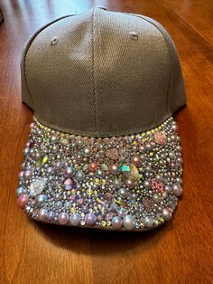 One-of-a-kind custom blinged-out ball cap style hat with a velcro strap on the back. There is an opening for a ponytail too. The pictures don't show how sparkly this hat is. It is grey with multi-colored jewels that hint at lavender, pink, and multi-faceted colors that are so vibrant when in the sun. Sassy and fun! Casual Adjustable Baseball Cap With Rhinestones, Rhinestone Baseball Cap One Size, Rhinestone Embellished One Size Baseball Cap, Casual Snapback Baseball Cap With Rhinestones, Adjustable Rhinestone Baseball Cap With Curved Brim, Trendy Rhinestone Adjustable Baseball Cap, Adjustable Rhinestone Cap, Rhinestone Baseball Cap, Bling Hat