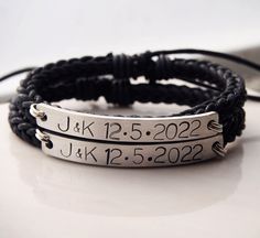 a couple of bracelets that are sitting on top of a white table with a black cord