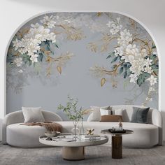 a living room with white furniture and flowers on the wall