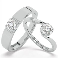 two white gold wedding rings with diamonds on each side and one diamond in the middle